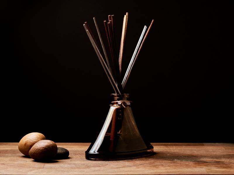 Warm and rustic aroma setting with incense sticks in a bottle, perfect for relaxation.